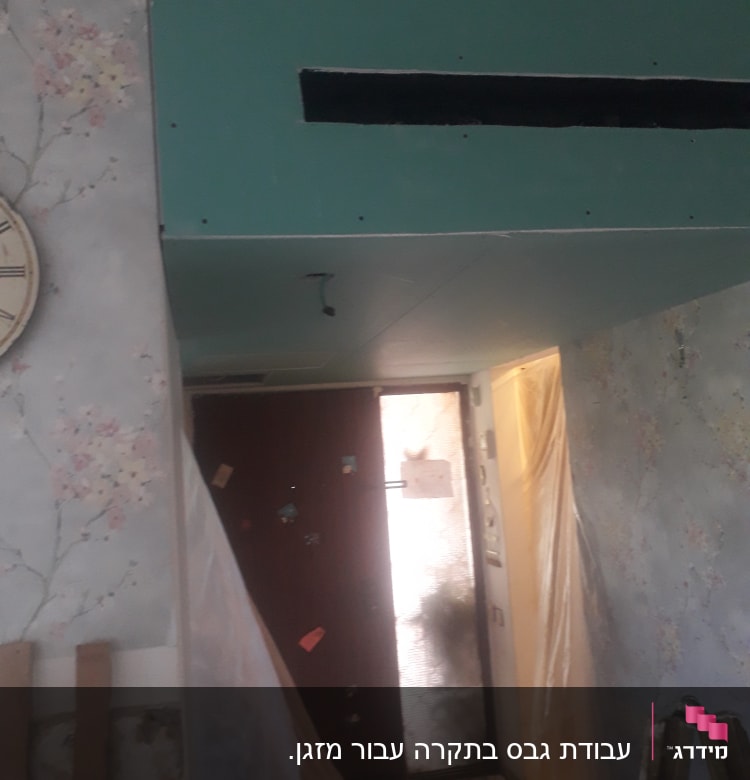 קיר גבס ירוק עם חור מלבני בתקרה